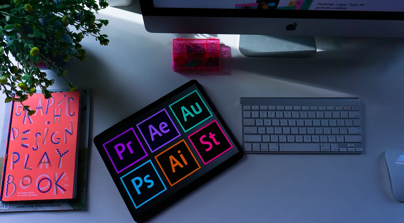 A book, tablet, mouse, keyboard and monitor on a desktop